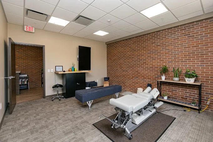 Warm, welcoming Bloom Chiropractic treatment room in West Des Moines with exposed brick and natural light